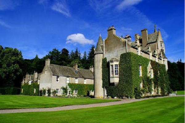 Ballindalloch Castle Garden on a sunny day with deep blue skys, green lawns and the stone castle in the background