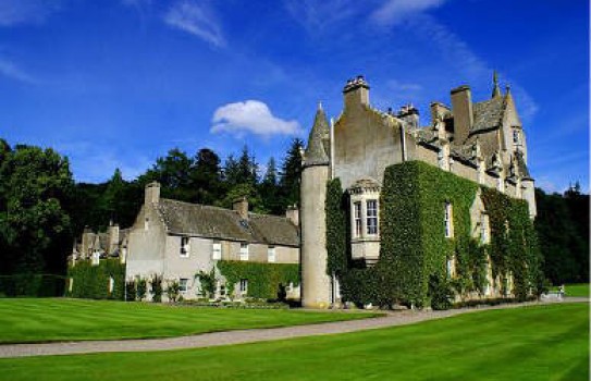 Ballindalloch Castle Garden on a sunny day with deep blue skys, green lawns and the stone castle in the background